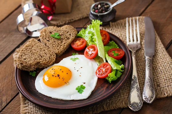 El desayuno el Día de San Valentín - los huevos fritos y el pan en forma del corazón —  Fotos de Stock