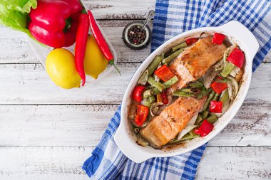 Baked salmon fillet with vegetables and herbs.