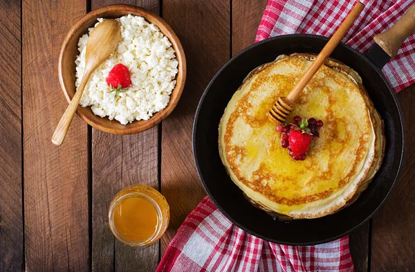 Panqueques dorados con mermelada de arándanos y miel en un estilo rústico — Foto de Stock