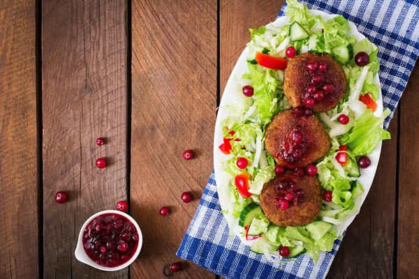 Uicy meat cutlets with cranberry sauce and salad on a wooden table in a rustic style. — ストック写真