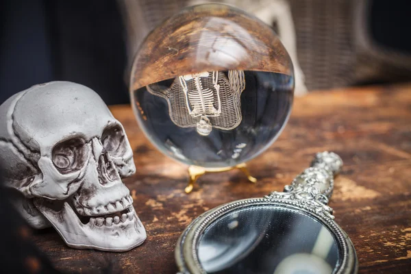 Skallen, gammal spegel och kristallkula med eftertanke skelett — Stockfoto