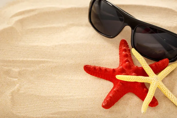 Seesterne und Sonnenbrillen auf dem Sand — Stockfoto