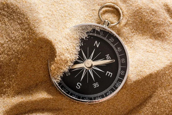 Black compass in beach sand — Stock Photo, Image