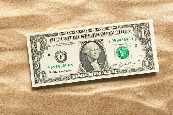 Ένα δολάριο τραπεζογραμματίων στην άμμο — Φωτογραφία Αρχείου