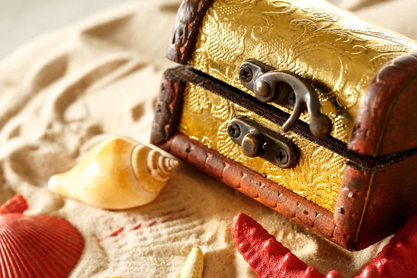 Schatztruhe mit Muscheln auf Sand — Stockfoto