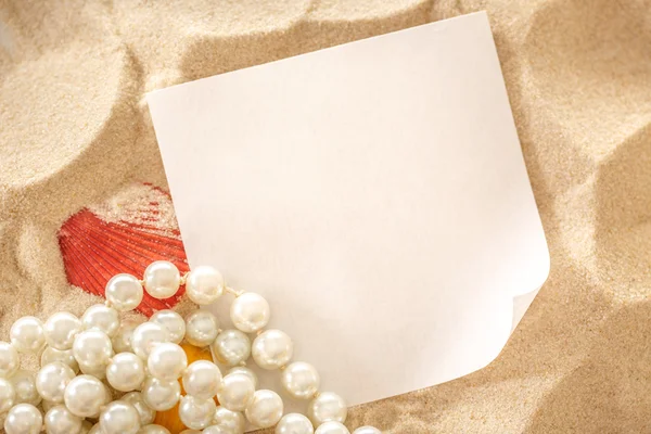 Pearl, schelpen en papier op zand — Stockfoto