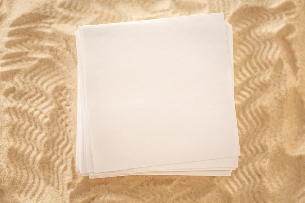 Hojas de papel en blanco sobre arena — Foto de Stock