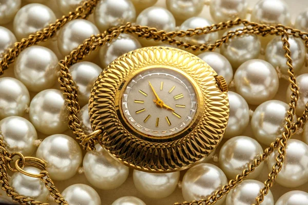 Golden watch in closeup on pearls — Stock Photo, Image