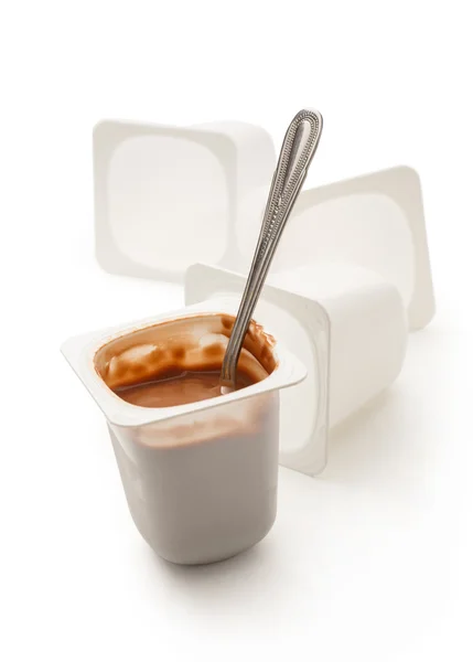 Open yogurt in pot with metal spoon — Stock Photo, Image
