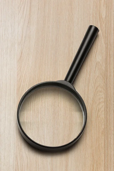 Magnifying glass on the wooden background — Stock Photo, Image