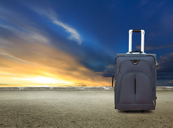 Чемодан на закате неба и дороги
