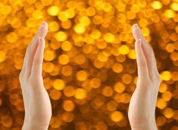 Female hands on golden background — Stock Photo, Image