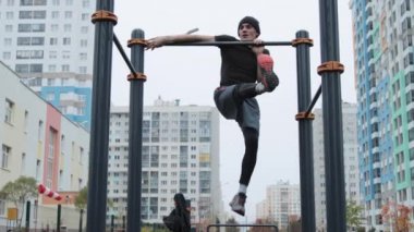 Kaslı adam spor sahasında antrenman yapıyor.