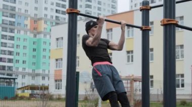 Kaslı adam spor sahasında antrenman yapıyor.