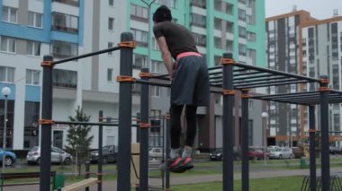 Kaslı adam spor sahasında antrenman yapıyor.