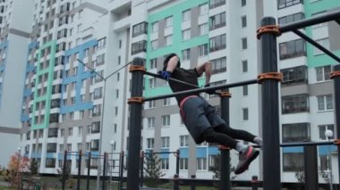 Kaslı adam spor sahasında antrenman yapıyor.