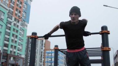 Kaslı adam spor sahasında antrenman yapıyor.