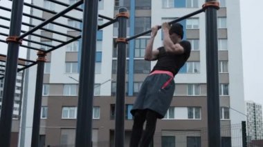 Kaslı adam spor sahasında antrenman yapıyor.