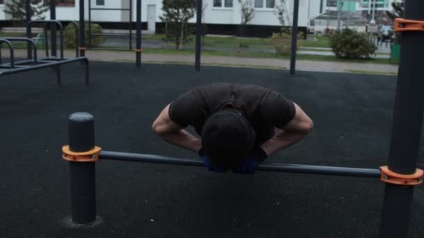 М'язистий чоловік тренується на відкритому повітрі на спортивному полі — стокове відео