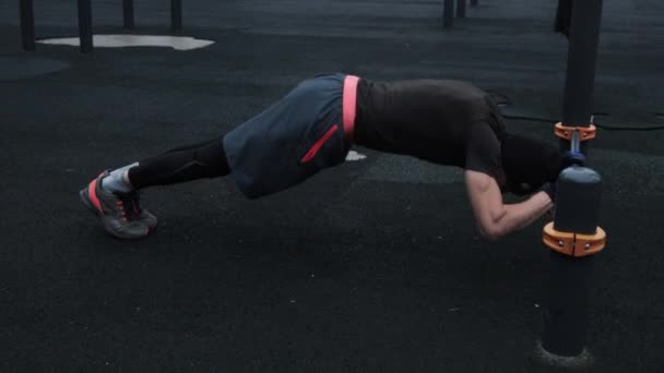 М'язистий чоловік тренується на відкритому повітрі на спортивному полі — стокове відео