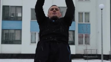 Adam kışın spor sahasında antrenman yapıyor.