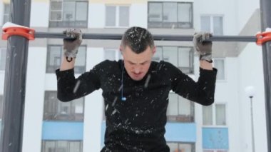 Adam kışın spor sahasında antrenman yapıyor.