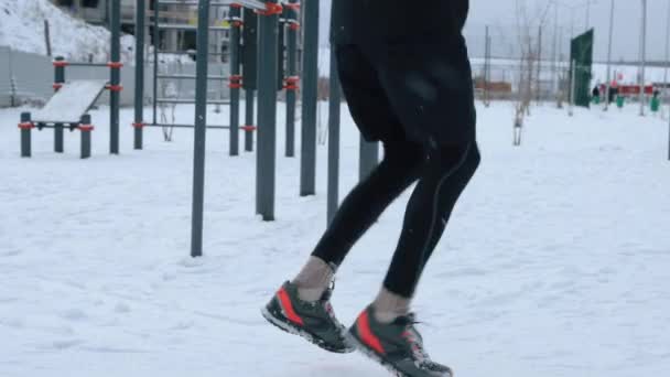 Människan tränar utomhus på idrottsplats på vintern — Stockvideo