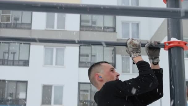Muž trénuje venku na sportovním hřišti v zimě — Stock video