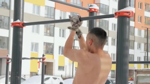 Svalnatý muž trénuje nahoře bez na sportovním hřišti v zimě — Stock video