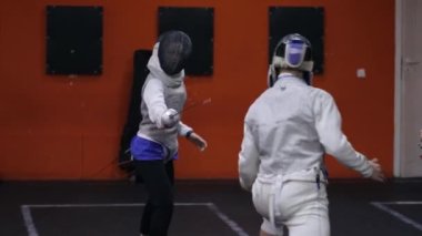 Gençler eskrim okulunda eskrim pratiği yapıyor.