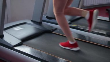 Koşu bandında eğitim gören genç bir kadın.