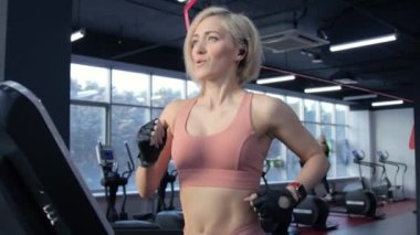 Koşu bandında eğitim gören genç bir kadın.