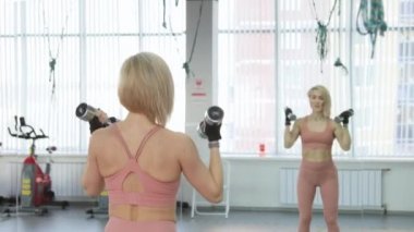 Genç kadın spor kulübünde antrenman yapıyor.