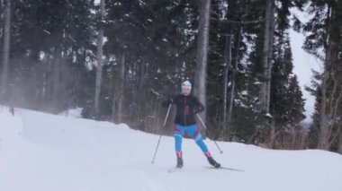 Genç bir kadın ormanda kayak yapıyor.