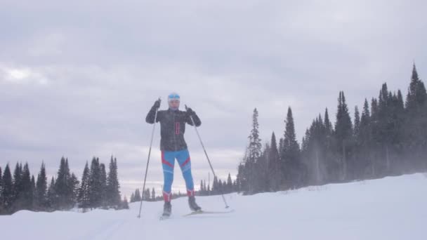 Молодая женщина катается на лыжах по лесной тропе — стоковое видео
