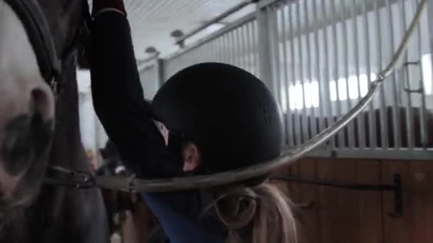 Meisje voorbereiding paard voor paardrijden — Stockvideo