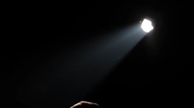 Adam elini ışığa doğru çekiyor.