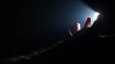 Adam elini ışığa doğru çekiyor.