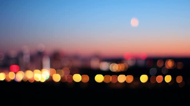 Fondo borroso de la ciudad al atardecer con la luna en el cielo — Vídeo de stock