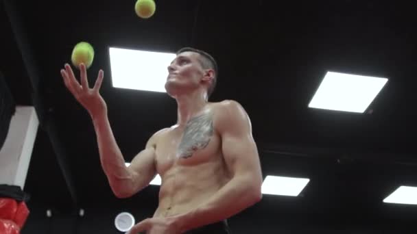 Svalnatý muž žonglování se třemi míčky — Stock video