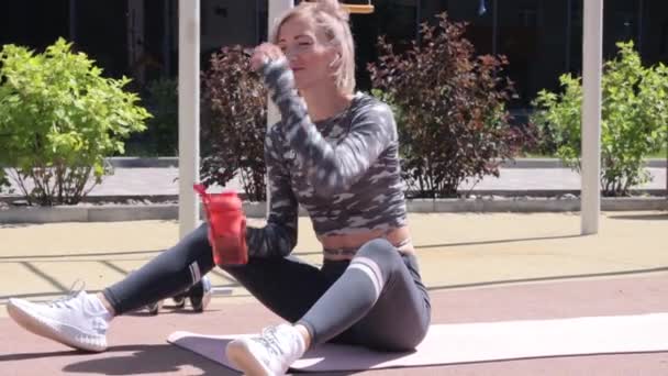 Mujer bebiendo agua después del entrenamiento — Vídeo de stock