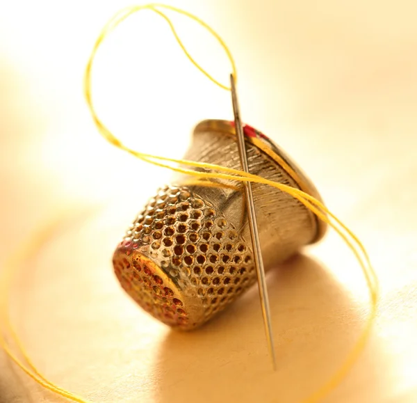 Sewing thimble and needle with thread — Stock Photo, Image