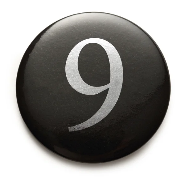 Numero bianco 9 sul distintivo nero — Foto Stock