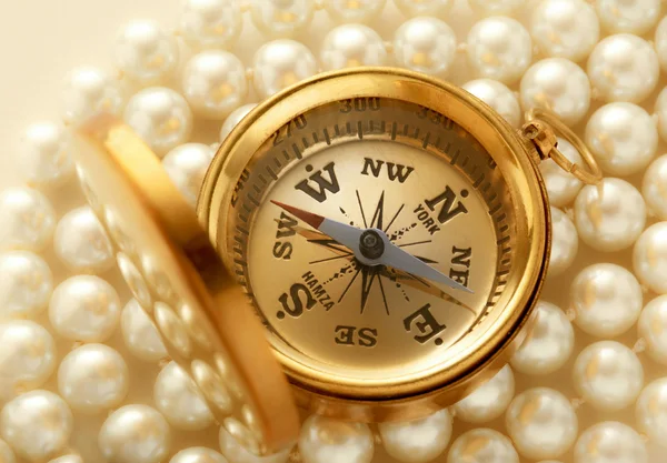 Goldener Kompass auf Perlen — Stockfoto