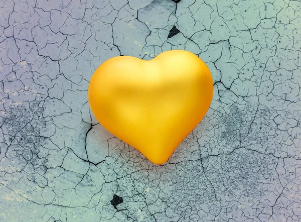 Golden heart on cracked background — Stock Photo, Image