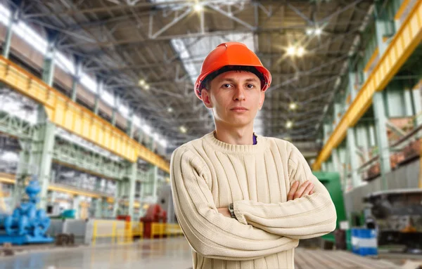 Workman in red helmet in the workshop — Stock Photo, Image