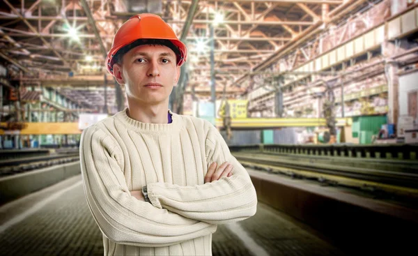 Workman i röd hjälm i verkstaden — Stockfoto