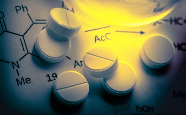 Chemistry reaction formula with white pills — Stock Photo, Image