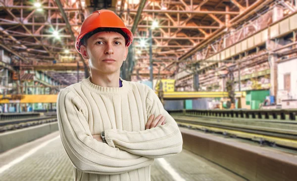Workman i röd hjälm i verkstaden — Stockfoto