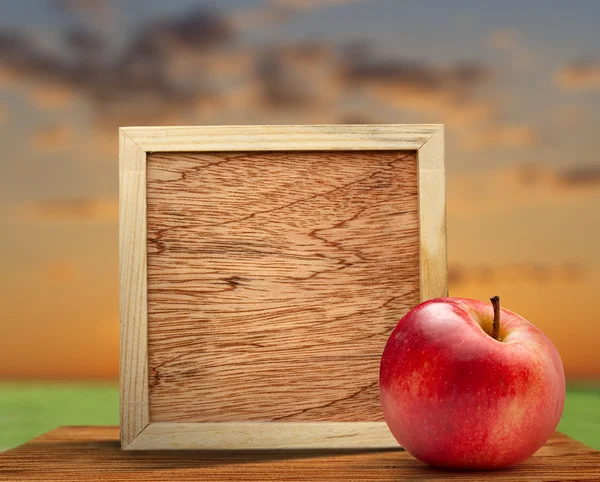 Red apple with wooden frame — Stock Photo, Image